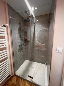 a shower with a glass door in a bathroom at Chic apartment with panoramic view in Caen