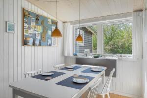 a dining room with a table and chairs in a kitchen at 20399-Samso-Laerkevej-24 in Nordby