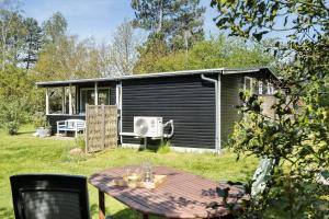 a picnic table in front of a small house at 20399-Samso-Laerkevej-24 in Nordby
