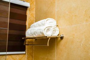une pile de serviettes sur un porte-serviettes dans une salle de bain dans l'établissement PEK Villa, Cozy Luxury Hideouts, 25 mins from Airport, à North Legon 132 autres photos