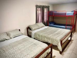 a bedroom with two beds and a bunk bed at Isabella Hostel and Pool in Alto Boquete +16 photos