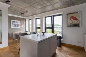 a kitchen with a island and a dining room with a table at Apartamenty Przystanek Przy Klifie in Gdynia
