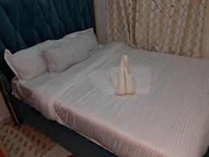 Una cama con dos pares de zapatos encima en Nakuru cozy stay, en Nakuru