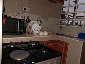 una cocina con estufa y microondas en Nakuru cozy stay, en Nakuru