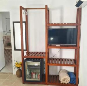 a wooden shelf with a television in a room at Porto Mar de Búzios in Búzios