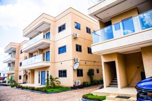 un grand immeuble d'appartements avec balcons sur une rue dans l'établissement PEK Villa, Cozy Luxury Hideouts, 25 mins from Airport, à North Legon