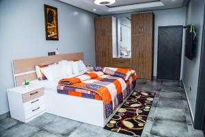 une chambre avec un lit avec une couette orange et bleue dans l'établissement PEK Villa, Cozy Luxury Hideouts, 25 mins from Airport, à North Legon