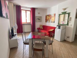 a living room with a table and a red couch at Casa Ischia in Perugia