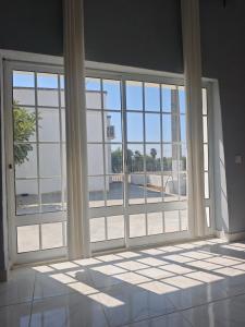 an empty room with large glass doors with a view of a building at QingQing民宿 in Moncarapacho