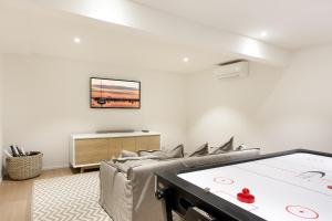 a living room with a couch and a tv on the wall at Luxury rainforest retreat, Little Cove in Noosa Heads