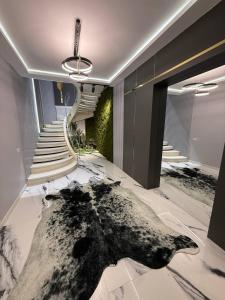 a lobby with a large rug on the floor and stairs at Пентхаус in Dushanbe
