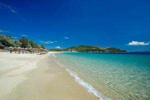 a beach with a group of umbrellas and the ocean at Casa Porto in Ierissos