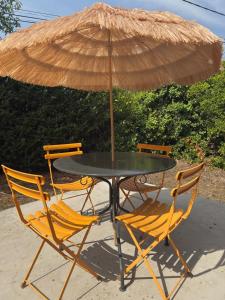 a table with two chairs and an umbrella at Maison familiale , piscine chauffée - Jardin - Toulouse in Cugnaux