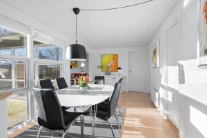 a dining room with a white table and black chairs at AE238-Aeroskobing-Skraningen-1 in Ærøskøbing
