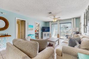 Una sala de estar con dos sofás y un televisor. en Bayview 67, en Orange Beach