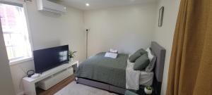 Un dormitorio con una cama y un televisor de pantalla plana. en Cozy Studio Walk to Shops, Quick Drive to DC, en Silver Spring