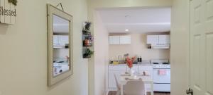 eine weiße Küche mit einem Tisch und einem Spiegel in der Unterkunft Cozy Studio Walk to Shops, Quick Drive to DC in Silver Spring