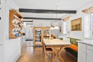a kitchen and dining room with a wooden table at AE293-Aeroskobing-Stokkeby-Hovedgade-19 in Ærøskøbing +14 photos