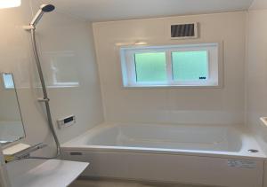 a white bathroom with a tub and a window at Work Shop Camp Resort Forest and Lake Paradise - Vacation STAY 11809v in Fujikawaguchiko