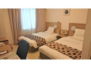 a hotel room with two beds and a desk at Smile Hotel Okinawa Naha - Vacation STAY 04109v in Naha