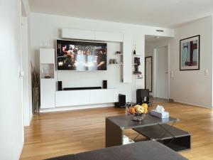 a living room with a television on a wall at Modern 3-Room Apartment in Stuttgart City Area in Stuttgart