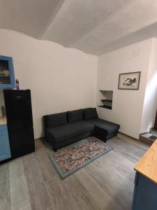 a living room with a black couch and a rug at L'angolo dei mestieri in Perugia +1 photo