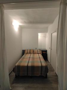 a bedroom with a bed in a white room at L'angolo dei mestieri in Perugia