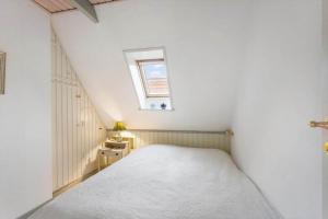 a small white bedroom with a bed and a window at AE282-Marstal-Dronningestraede-8 in Marstal