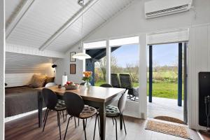 a dining room with a table and chairs and a bedroom at AE311-Aeroskobing-Hanses-Ager-11 in Ærøskøbing