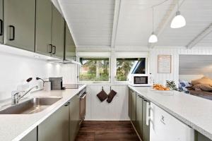 a kitchen with white counters and a sink and a window at AE311-Aeroskobing-Hanses-Ager-11 in Ærøskøbing +22 photos
