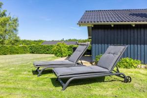 two lounge chairs sitting on the grass in front of a house at SB102-Sydals-Laerkemose-18 in Neder Lysabild