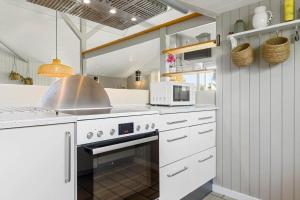 a kitchen with a stove and a microwave at SB102-Sydals-Laerkemose-18 in Neder Lysabild