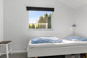 a bedroom with a bed and a window at SB102-Sydals-Laerkemose-18 in Neder Lysabild