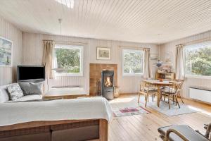 a bedroom with a bed and a table and a fireplace at SB50626-Sydals-Egemose-157 in Skovmose