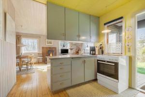 a kitchen with green cabinets and a dining room at SB50626-Sydals-Egemose-157 in Skovmose