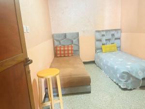 a room with two beds and a stool and a table at Msn in Rabat