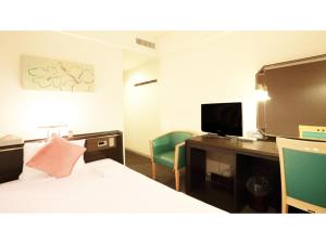 a hotel room with a bed and a desk and a tv at Smile Hotel Naha City Resort - Vacation STAY 05994v in Naha