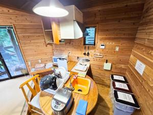 a kitchen with a wooden wall with a wooden table at Washiki Shiki no Sato Cottage - Vacation STAY 03104v in Wajiki