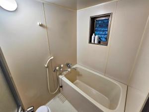 a bathroom with a bath tub and a toilet at Washiki Shiki no Sato Cottage - Vacation STAY 03104v in Wajiki