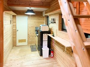 une cuisine dans une cabane en rondins avec un escalier dans l'établissement Washiki Shiki no Sato Cottage - Vacation STAY 03120v, à Wajiki