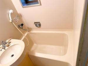 une salle de bain avec un lavabo et une baignoire dans l'établissement Washiki Shiki no Sato Cottage - Vacation STAY 03120v, à Wajiki 8 autres photos