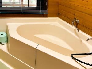 a white bath tub in a bathroom with a window at Washiki Shiki no Sato Cottage - Vacation STAY 02745v in Wajiki