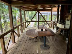 a wooden porch with two tables and a bench at Washiki Shiki no Sato Cottage - Vacation STAY 02745v in Wajiki