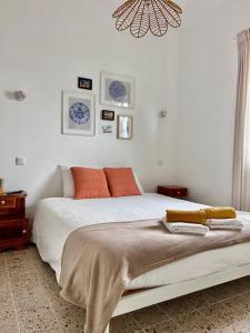 Un dormitorio con una cama con almohadas naranjas y una lámpara de araña. en Refúgio com Jardim no Coração de Aveiro, en Aveiro