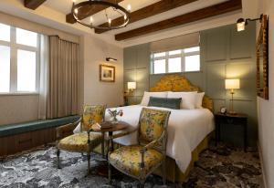 a bedroom with a bed and two chairs and a table at Rosemead House in Victoria