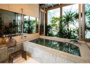 a large bathroom with a large tub with windows at Hayama Yashiro - Vacation STAY 19904 in Hayama