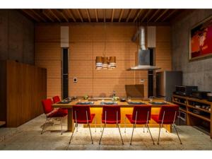 a kitchen with a large yellow table with red chairs at Hayama Yashiro - Vacation STAY 19904 in Hayama