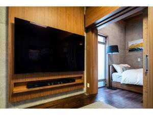 a large flat screen tv in a room with a bed at Hayama Yashiro - Vacation STAY 19904 in Hayama