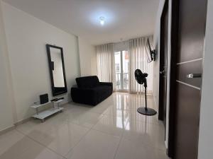 a living room with a black chair and a mirror at Edificio Verona 57 - Apartamento en Piedecuesta in Piedecuesta