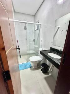 a bathroom with a toilet and a sink and a shower at Apartamento de Serra in Ubajara +2 photos